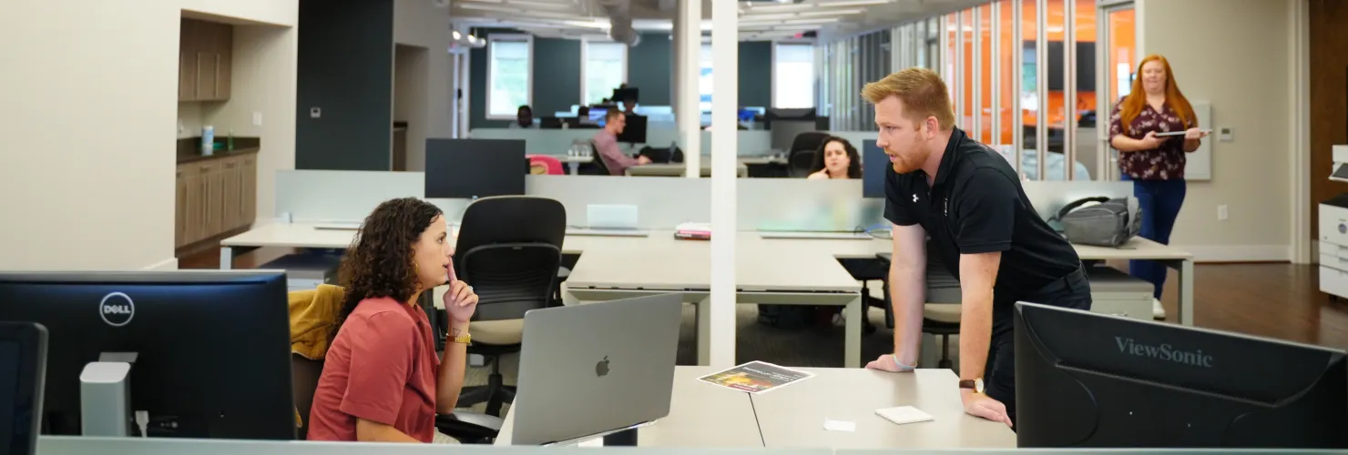 Cyberwoven team members conversing in the office.